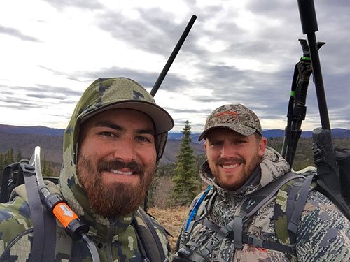 Portrait of two individual with hills.