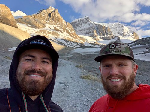 Portrait of two individual with mountains in background.